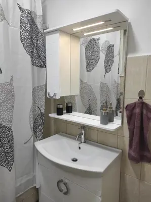 a bathroom with a sink and a mirror at Welcome Apartman in Tuzla