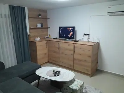 a living room with a couch and a tv on a cabinet at Apartmani BET Gradačac 1 Maj broj 24 in Gradačac