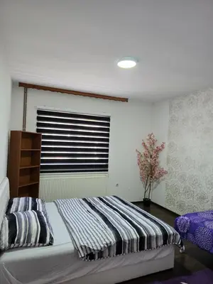 a bedroom with a large bed with a window at Apartman Vany in Tuzla