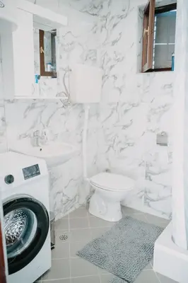 a white bathroom with a toilet sink and a washing machine at Vidovo Domacinstvo in Banja Luka