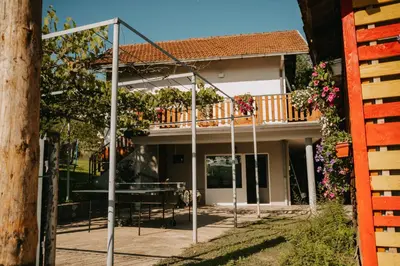 a house with a balcony with a table and chairs at Vidovo Domacinstvo in Banja Luka