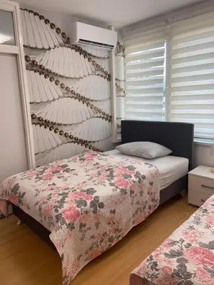 a bedroom with two beds and a wall with windows at Apartman Citylux in Bihać