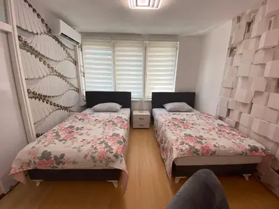 a bedroom with two beds and a window at Apartman Citylux in Bihać