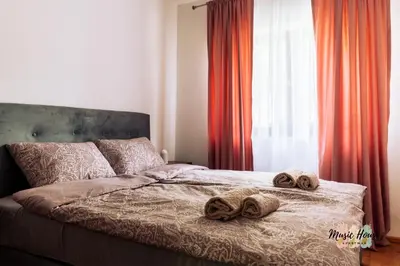 a bed with two towels on it with a window at Music House Apartment in Tuzla