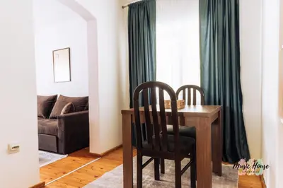 a living room with a table and chairs and a couch at Music House Apartment in Tuzla