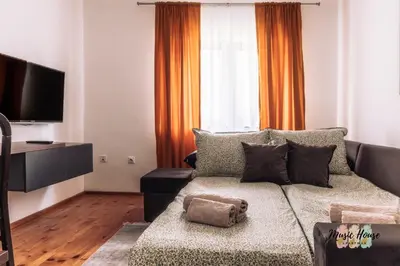 a living room with a couch and a flat screen tv at Music House Apartment in Tuzla