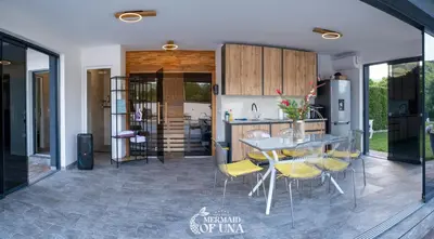 a kitchen with a table and chairs in a kitchen at Villa Mermaid of Una in Bihać