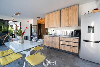 a kitchen with a table and a refrigerator at Villa Mermaid of Una in Bihać