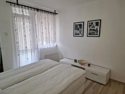a white bedroom with a bed and a window at Apartman Lana in Bosanski Novi