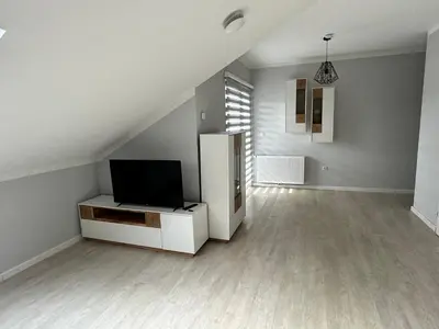 a living room with a television and a white refrigerator at XL Apartman in Teslić