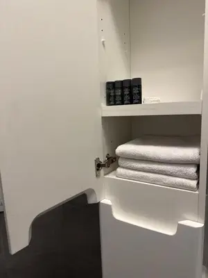 a bathroom with white towels on a shelf at XL Apartman in Teslić