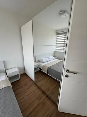 a small room with a bed and a mirror at XL Apartman in Teslić