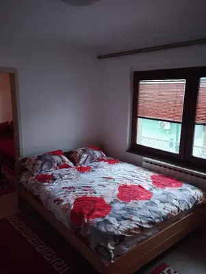 a bedroom with a bed with red roses on it at Apartmani Emir in Visoko