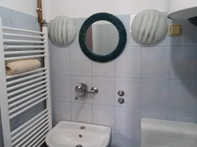 a bathroom with a white toilet and a mirror at Apartmani Emir in Visoko