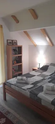 a bedroom with two beds and a book shelf at Ravne weekend house in Visoko