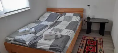a bed in a small room with a table at Ravne weekend house in Visoko