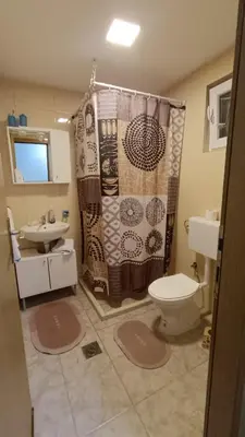 a bathroom with a shower curtain and a toilet at Positive energy in Visoko
