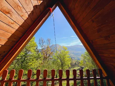 a window in a cabin with a view of the mountains at Positive energy in Visoko