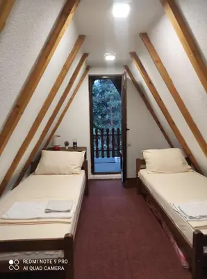 two beds in a room with a window at Positive energy in Visoko