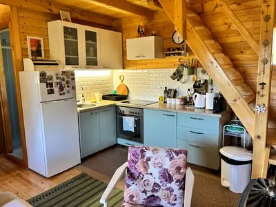 a kitchen with white appliances and a wooden ceiling at Brvnaria in Slatina Varoš