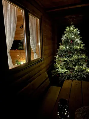 a christmas tree in a room with a wooden table at Brvnaria in Slatina Varoš