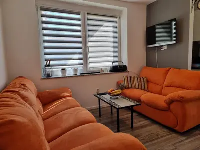 a living room with an orange couch and a table at Lavanda in Livno