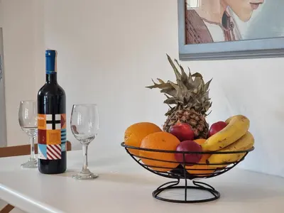 a bowl of fruit on a table with a bottle of wine at Lavanda in Livno