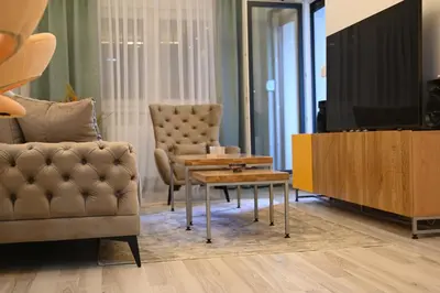 a living room with a couch and a table and a tv at Apartman Mosaic in Doboj