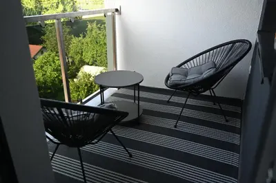 two chairs and a table on a balcony at Apartman Mosaic in Doboj