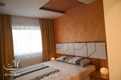 a bedroom with a bed with a headboard and a window at Apartman Mosaic in Doboj