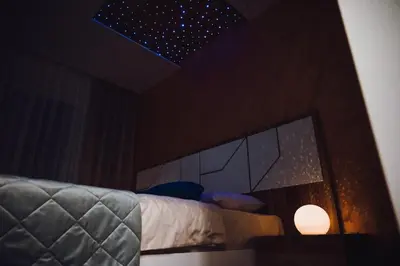 a bedroom with a bed with a mirror and a light at Apartman Mosaic in Doboj