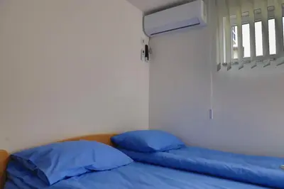 a bed with blue pillows in a room with a window at Konak kod Hame in Bihać