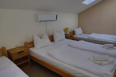a room with two beds and a tv on the wall at Konak kod Hame in Bihać