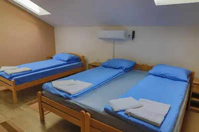 two beds in a room with blue sheets at Konak kod Hame in Bihać