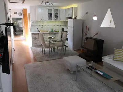 a kitchen and living room with a table and a refrigerator at Apartment Mirror in Visoko