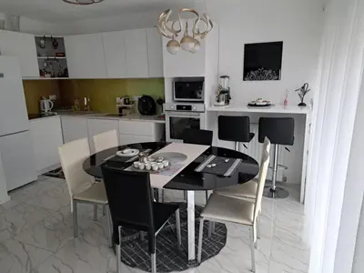 a kitchen with a black dining table and chairs at AM Una Lux House in Bihać