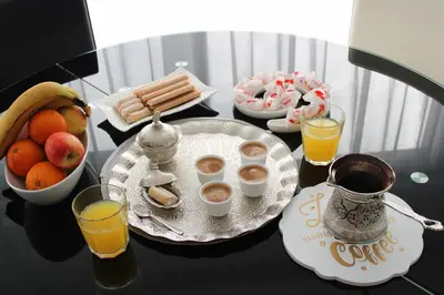 a table with a tray of breakfast foods and orange juice at AM Una Lux House in Bihać