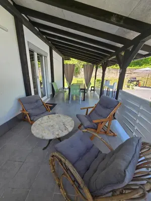 a patio with chairs and a table on a porch at Vikendica Lohovo in Bihać