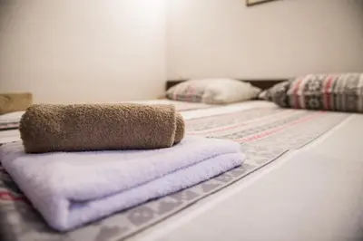 a bed with two beds with towels on it at Vikendica Lohovo in Bihać
