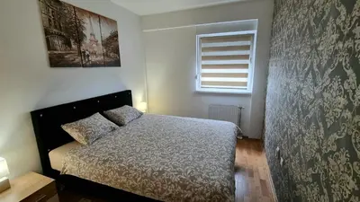 a small bedroom with a bed and a window at Apartman Court Prijedor in Prijedor