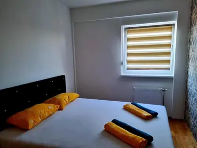 a bed with two pillows on it with a window at Apartman Court Prijedor in Prijedor