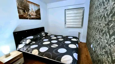 a bedroom with a bed with a black and white comforter at Apartman Court Prijedor in Prijedor