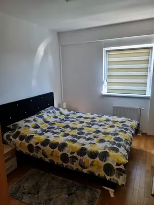 a bedroom with a bed with a yellow and blue comforter at Apartman Court Prijedor in Prijedor