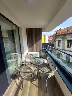 a balcony with a table and chairs on a balcony at ELITE Park Lake in Tuzla