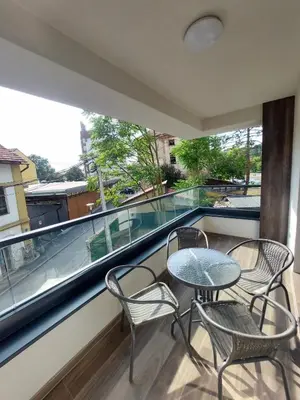 a balcony with three chairs and a table and a window at ELITE Park Lake in Tuzla
