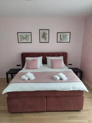 a bedroom with a large bed with pink pillows at ELITE Park Lake in Tuzla