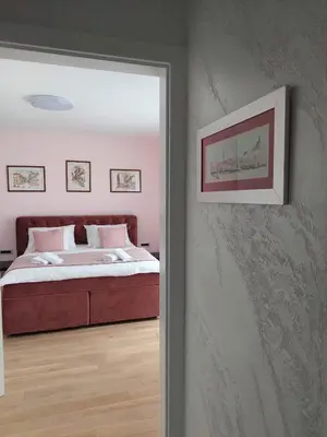 a bedroom with a bed and a door leading into a room at ELITE Park Lake in Tuzla
