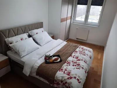 a bedroom with a bed with a tray of food on it at Apartman Stepe Stepanovica in Banja Luka