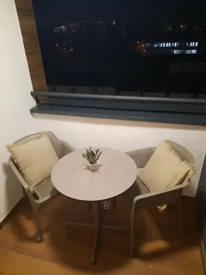 a table and chairs in a room with a window at Apartman Stepe Stepanovica in Banja Luka