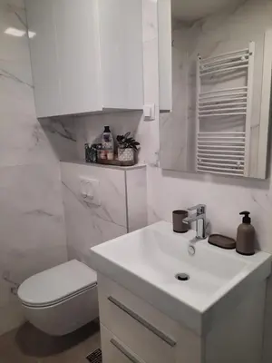 a white bathroom with a toilet and a sink at Apartman Stepe Stepanovica in Banja Luka
